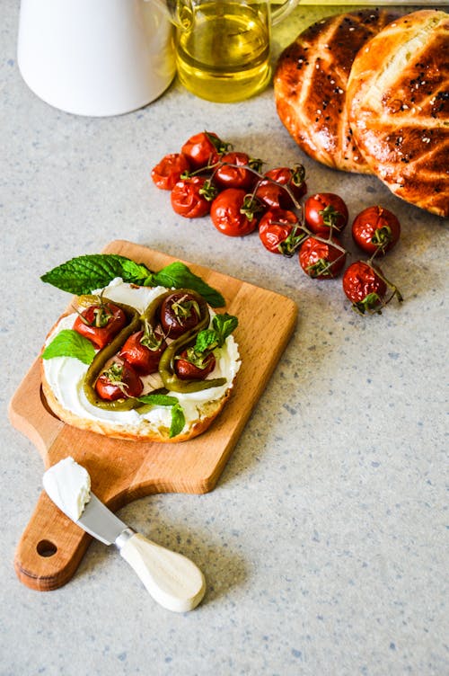 A bread with tomatoes and basil on it on a cutting board