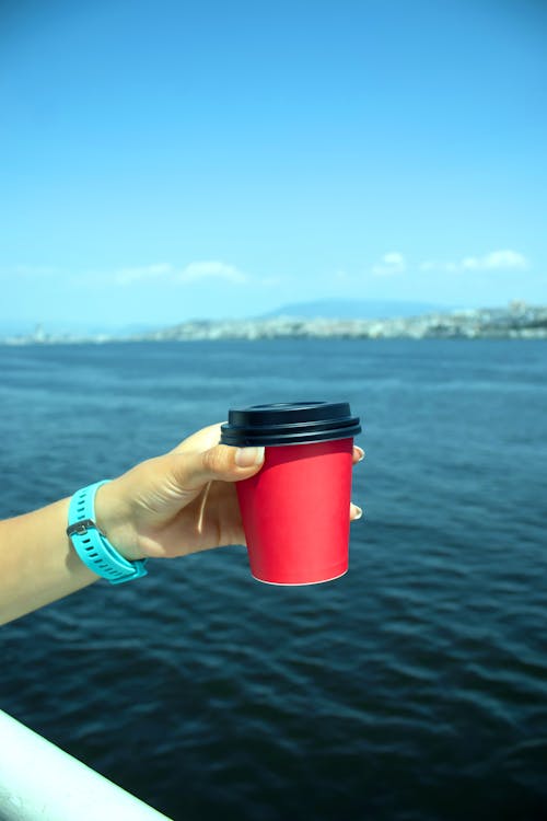 A person holding a red cup on a boat