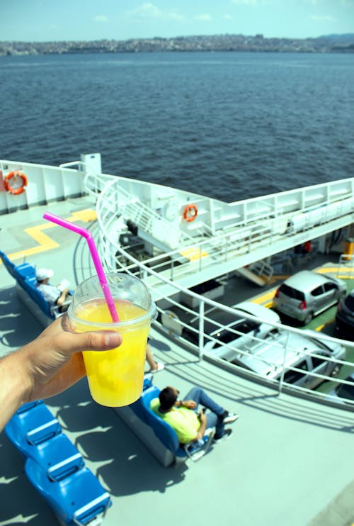 A person holding a drink on a ferry