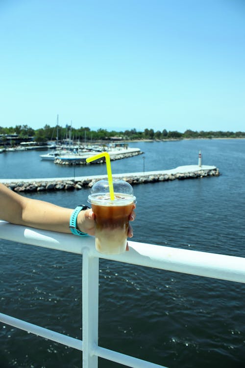 A person holding a drink on a boat