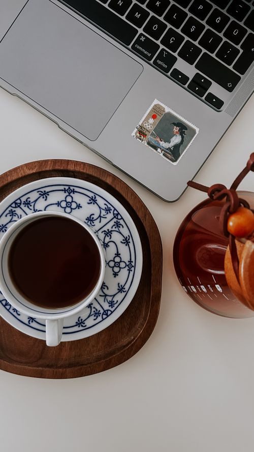 Free Overhead view of a coffee cup and laptop on a desk, creating a cozy workspace. Stock Photo
