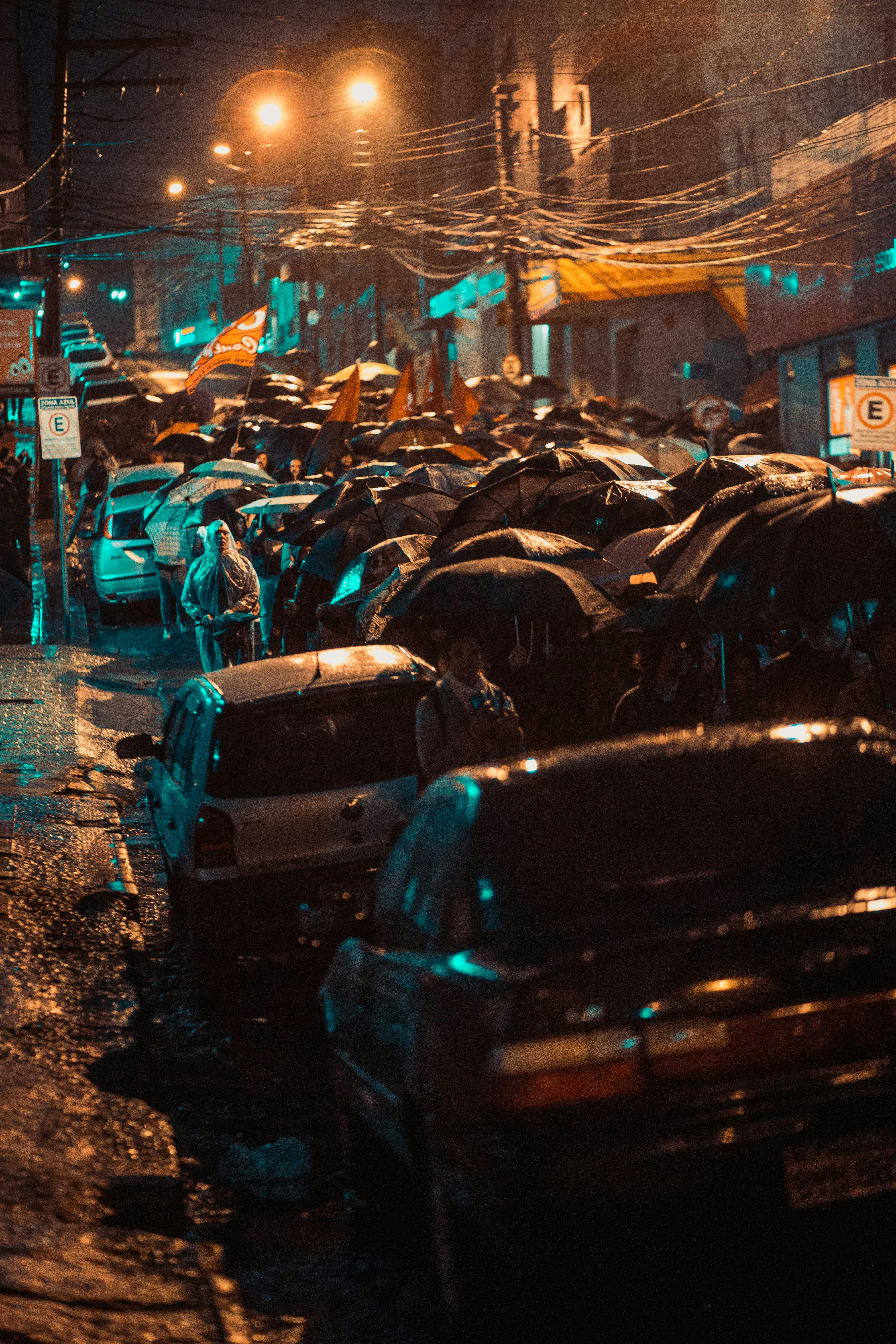 大雨中，城市街景依然充满活力，汽车穿梭，行人撑伞而行