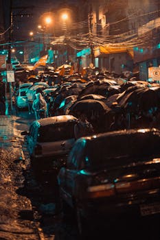 大雨中，城市街景依然充满活力，汽车穿梭，行人撑伞而行