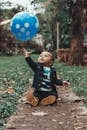 可爱的男婴在公园里伸手去拿蓝色气球，捕捉到欢乐和嬉戏