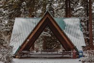 冬日森林中，白雪皑皑的凉亭映衬出一片宁静的景象