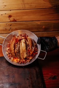 Delicious gourmet tacos in a pan with diced meat, held by a gloved hand.