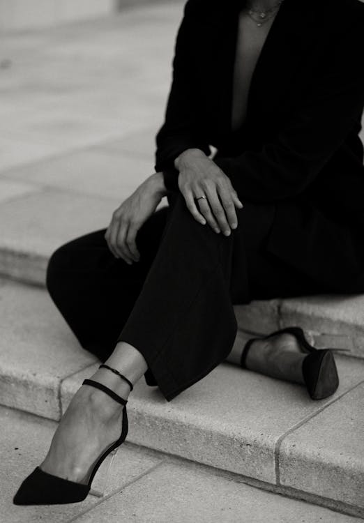 A woman in a black suit sitting on some steps