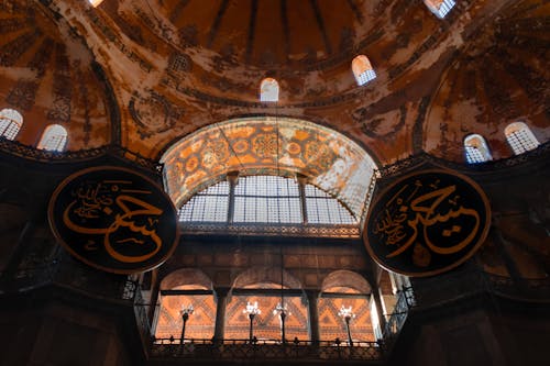 The inside of a building with a dome and arabic writing