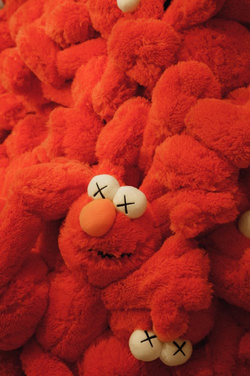 A pile of red stuffed animals with eyes