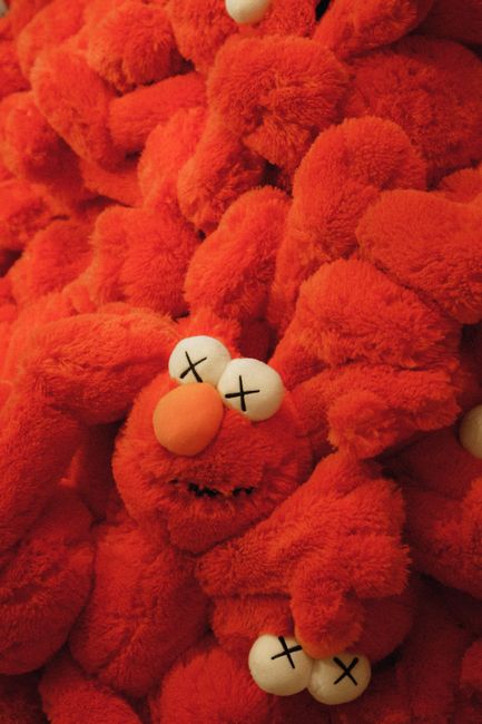 Collection of red plush toys stacked together, featuring distinct crossed eyes.