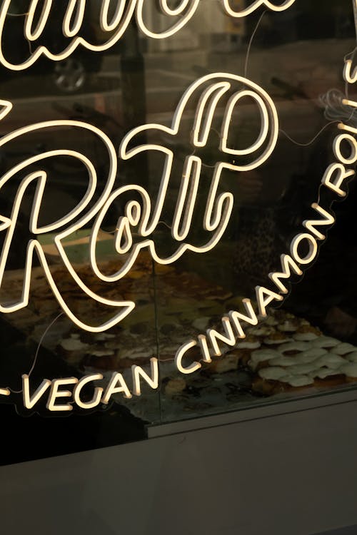 A neon sign that says, don't roll vegan cinnamon rolls