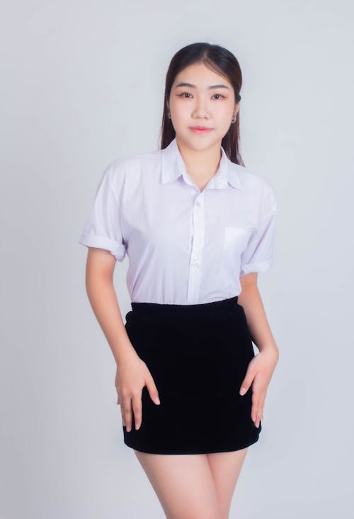A woman in a white shirt and black skirt