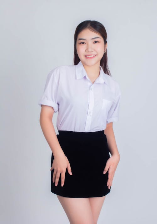 A young asian woman in a short skirt and blouse