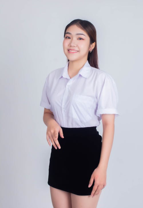 A young woman in a skirt and shirt posing for a photo
