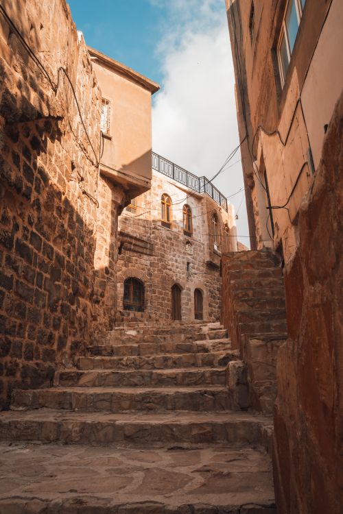 Free Explore the narrow stone stairway between rustic buildings in a historic urban setting. Stock Photo