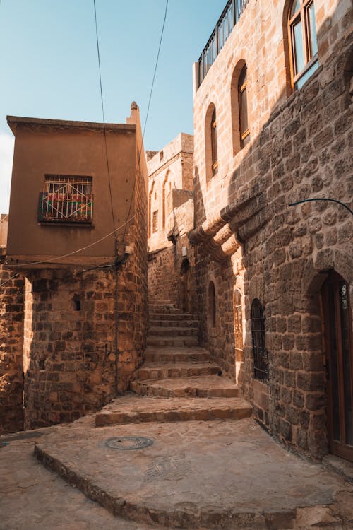 A narrow street with stone steps and balconies