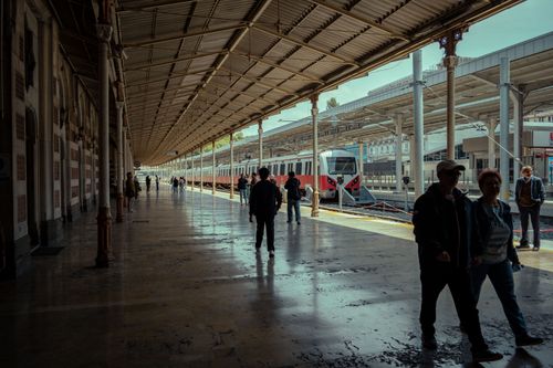 Free A busy train station with passengers walking on the platform and a train in view. Stock Photo