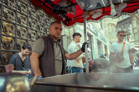 Street vendor cooking food in a bustling city market, surrounded by customers.