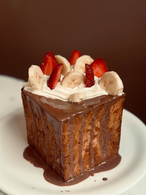 A piece of cake with chocolate, bananas and strawberries