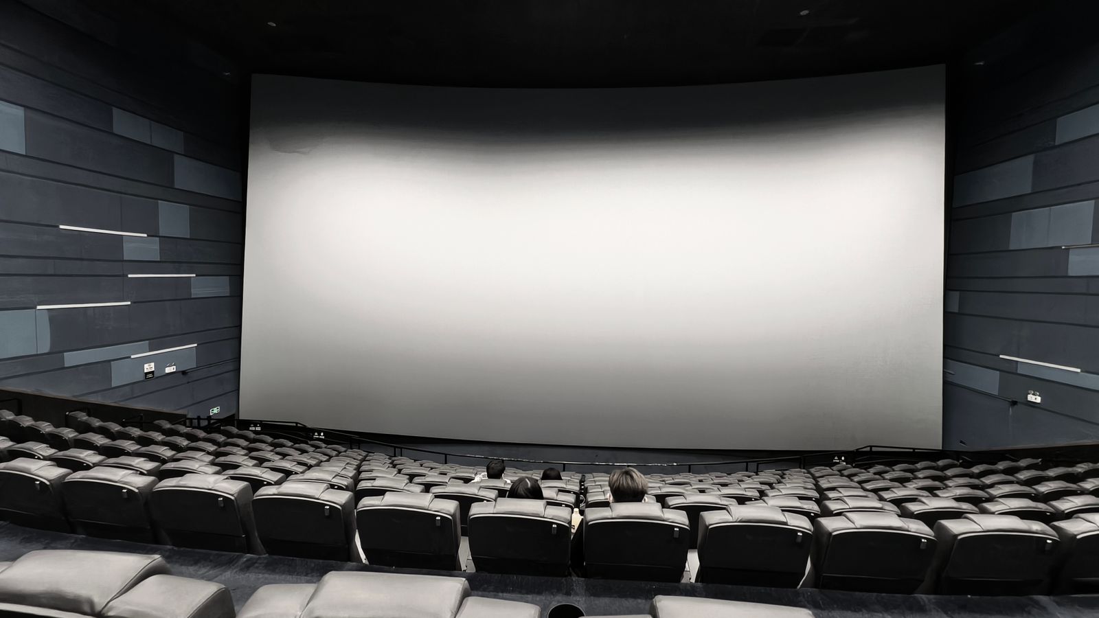 Cinema auditorium with a large screen and rows of seats