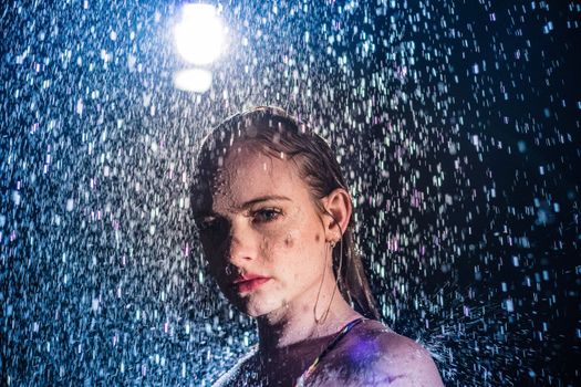 Artistic portrait of a woman under dramatic rain lighting in Miami.