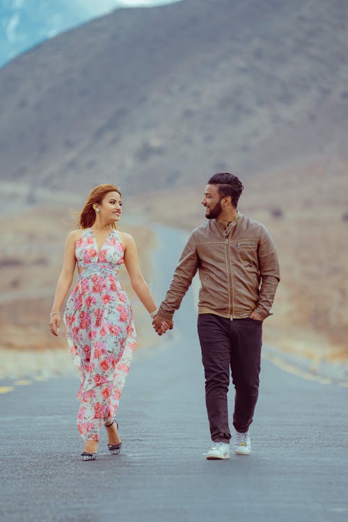A man and woman walking down a road in the mountains