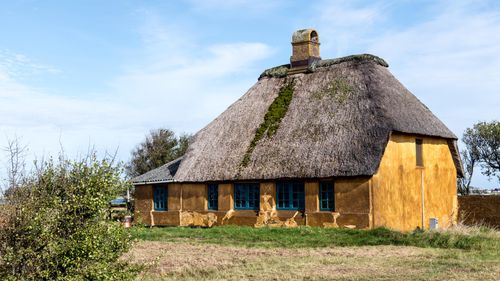 Free Charming thatched roof house in rural Hadersleben, Denmark, showcasing classic Scandinavian architecture. Stock Photo