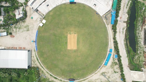 An aerial view of a cricket field with a green roof