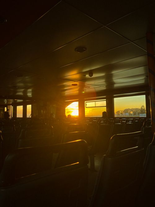 Free Serene sunset view from inside a boat with empty seats and warm lighting. Stock Photo