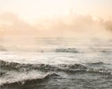 平静的海浪在日出的温暖阳光下轻轻翻滚