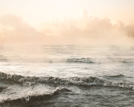 Peaceful ocean waves gently rolling under the warm light of sunrise.