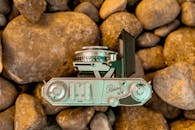 老式相机置于天然岩石之上，自上而下的视角凸显了复古经典的美学