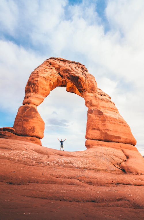 Free Man Standing On Arch At Canyon Stock Photo