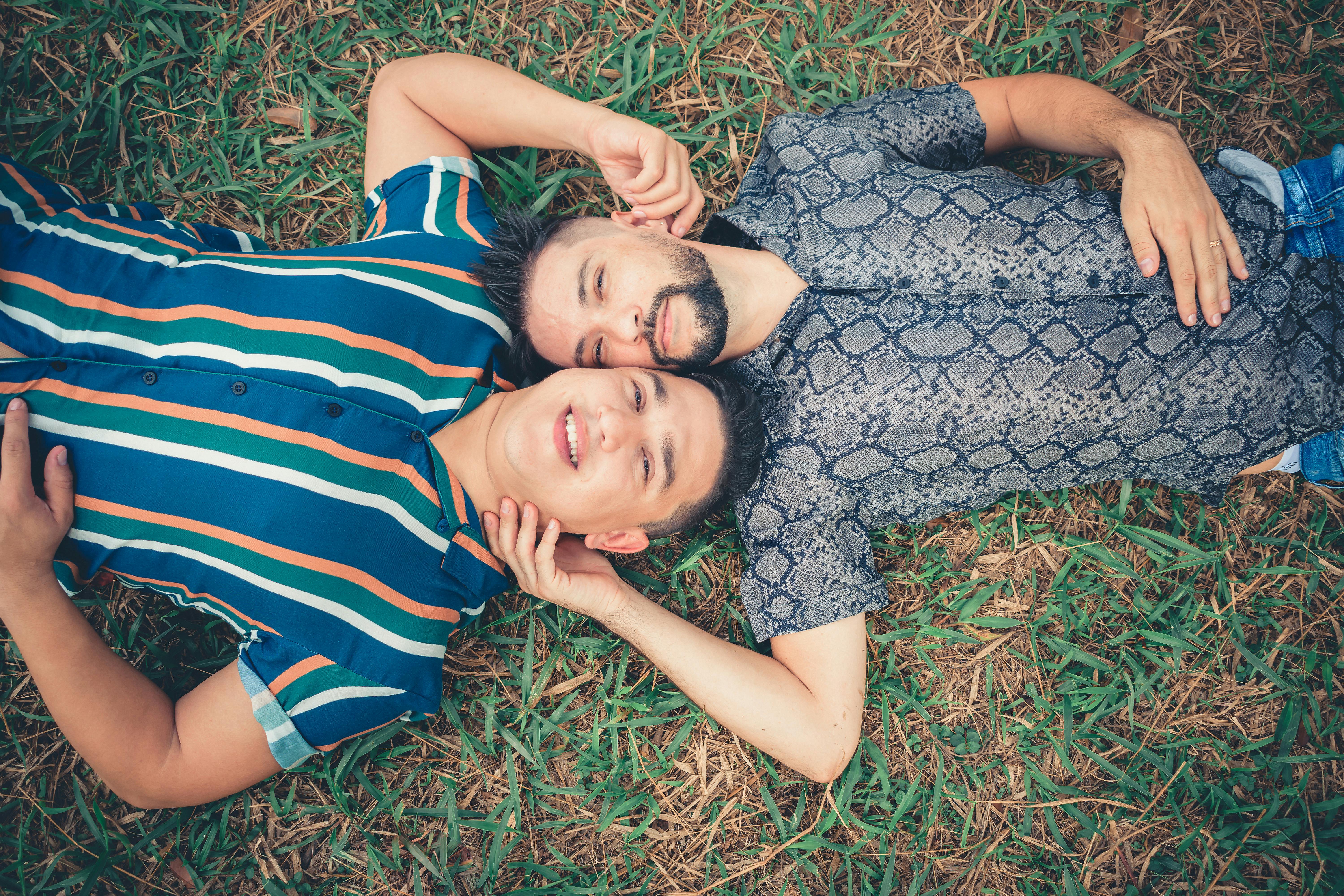 Two Men Lying On Green Grass · Free Stock Photo