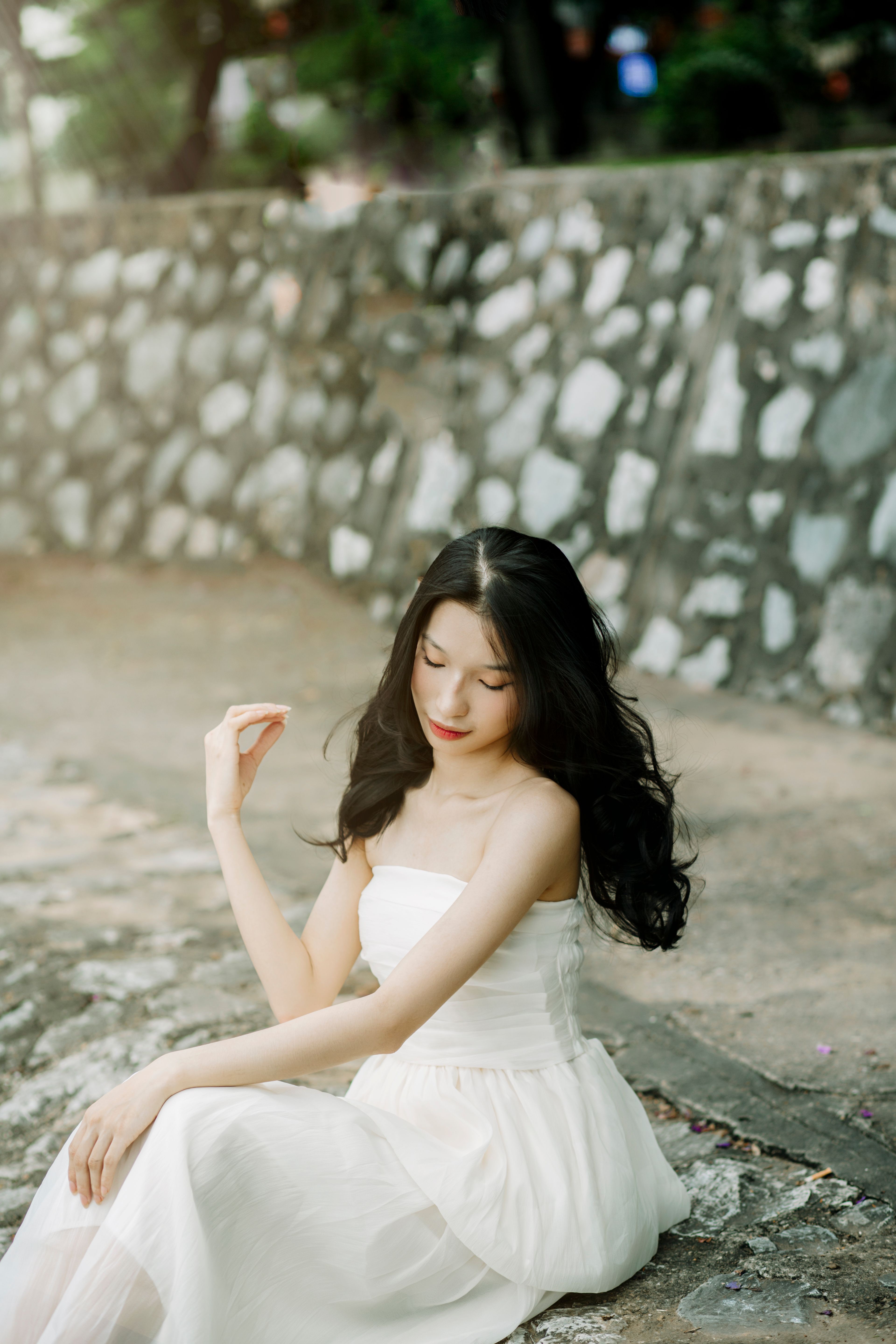 A Young Woman in a White Dress Sitting on the Ground · Free Stock Photo
