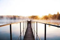 日出时分，一座乡村桥梁在雾蒙蒙的湖面上呈现出迷人的景象，宁静而美丽