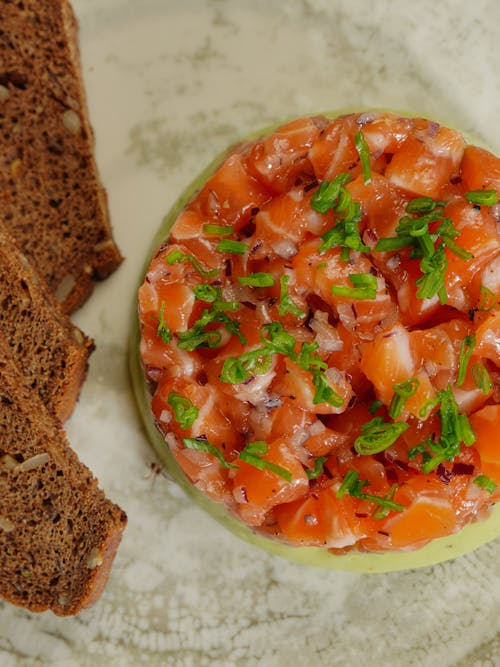 A plate with a bowl of tomato and bread