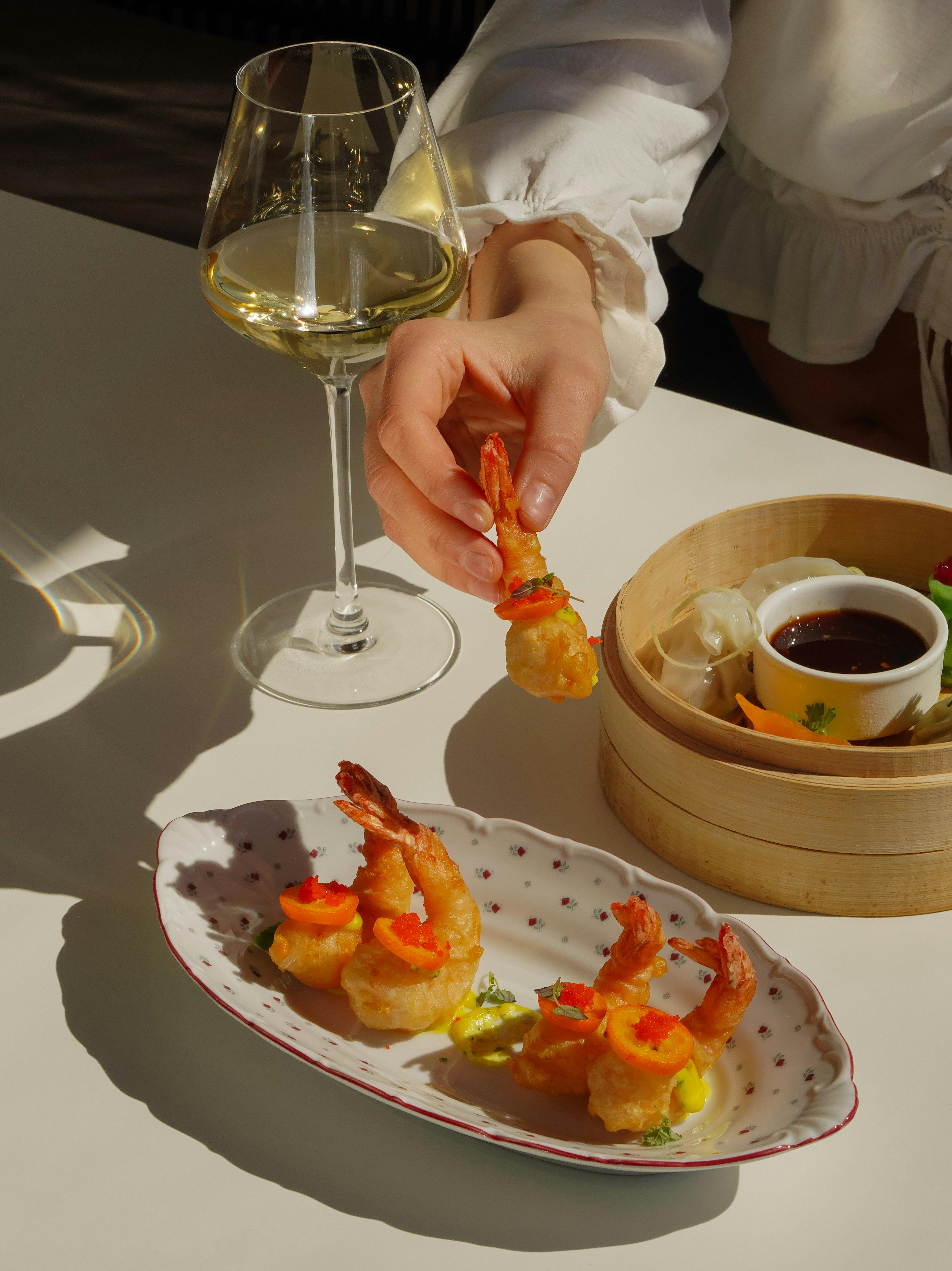 hand of person holding and eating shrimps