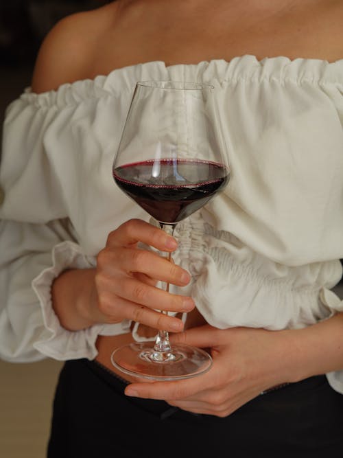 A woman holding a glass of wine in her hands