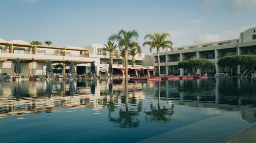 Free Elegant resort with a pool and palm trees under a clear blue sky in Greece. Stock Photo