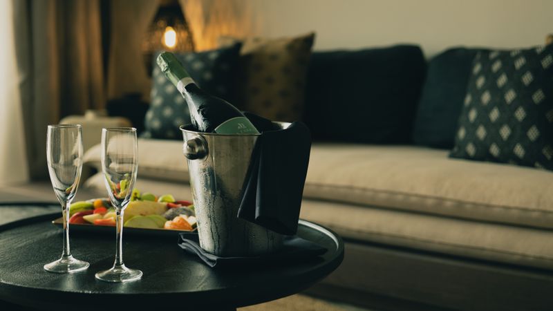 Chilled bottle and two glasses on a low table, photo by Jack Atkinson on Pexels