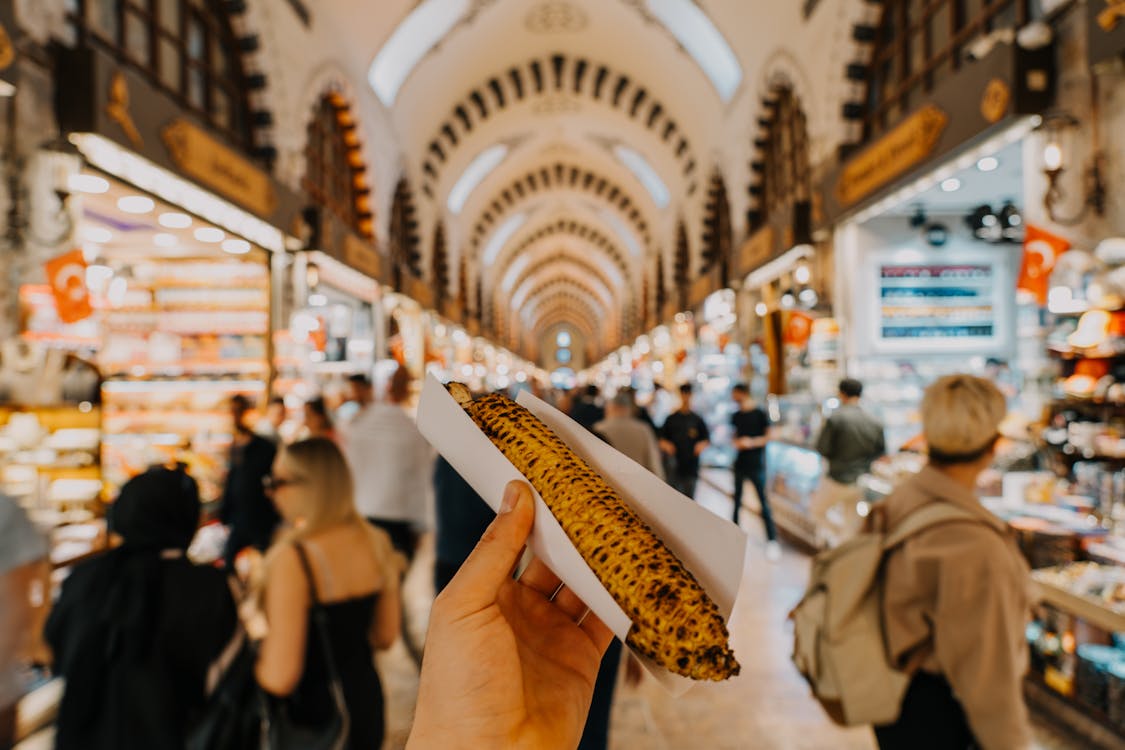 A person holding up a piece of bread in a market