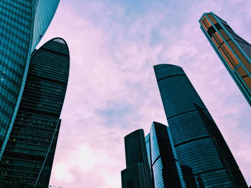 Free Dramatic upward view of Moscow skyscrapers under a pink sky. Modern architecture perspective. Stock Photo