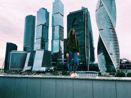 Photo of a Woman Standing in Front of Buildings