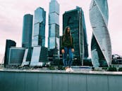 一位年轻女子站在莫斯科的摩天大楼前