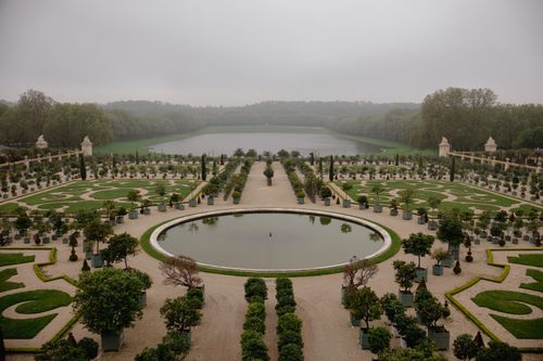 Free A foggy view of the Gardens of Versailles, showcasing symmetrical design and greenery. Stock Photo