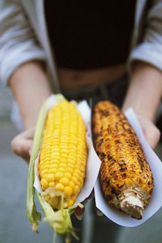 Close-up of grilled and fresh corn held by a woman in İstanbul, Türkiye