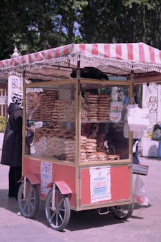 A vibrant street cart selling simit in bustling Istanbul, Türkiye.