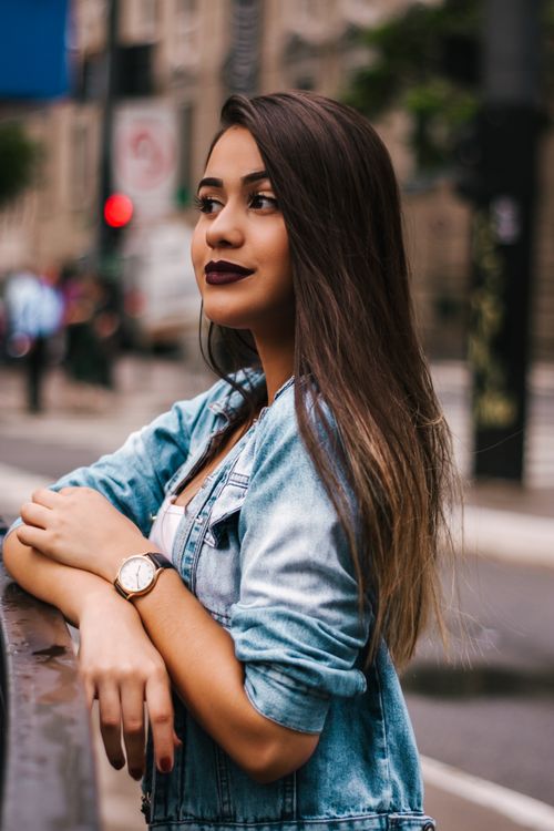 Free Young woman in denim jacket poses on a São Paulo street, exuding casual elegance. Stock Photo