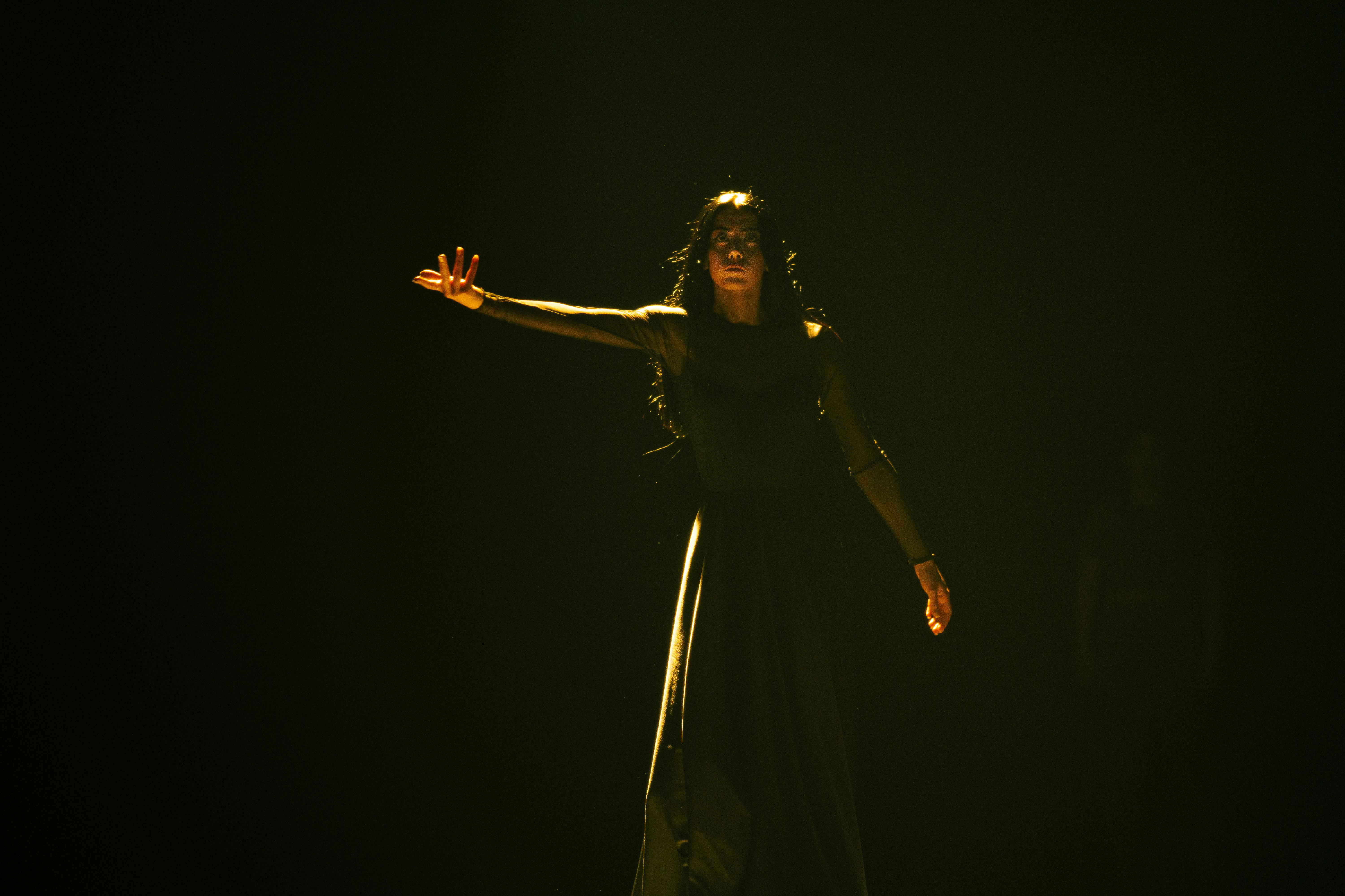 woman in black dress in darkness